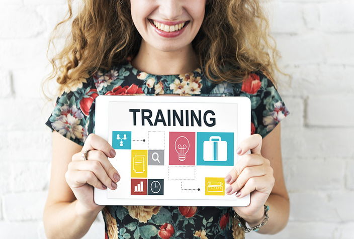Frau mit Schild mit dem Wort "Training" und Piktogrammen